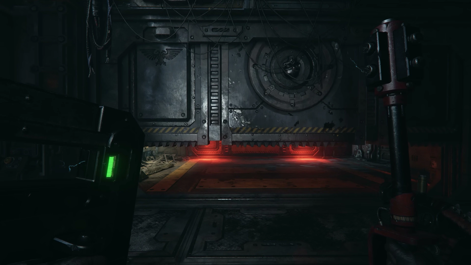 A raised shield and weapon frame a sealed door lit red in Darktide’s Arbites gameplay.